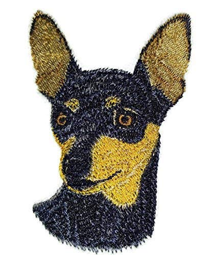 Embroidered patch of a dog's face with black and gold colors on a white background