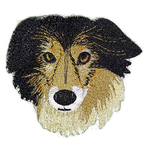 Embroidered patch of a dog's face with black, brown, and beige colors on a white background.