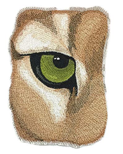 Embroidered patch of an owl's face with a green eye on a white background