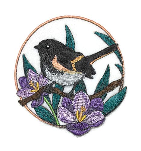 Embroidered patch of a bird on a branch with purple flowers and green leaves.