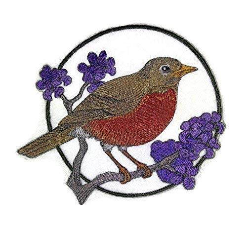Embroidered design of a bird on a branch with purple flowers on a white background