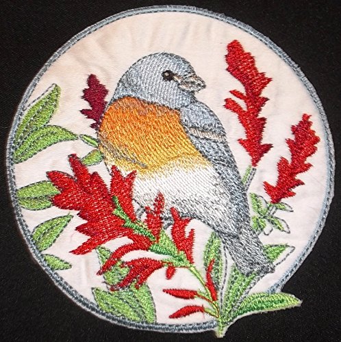 Embroidered patch of a bird and red flowers on a black background