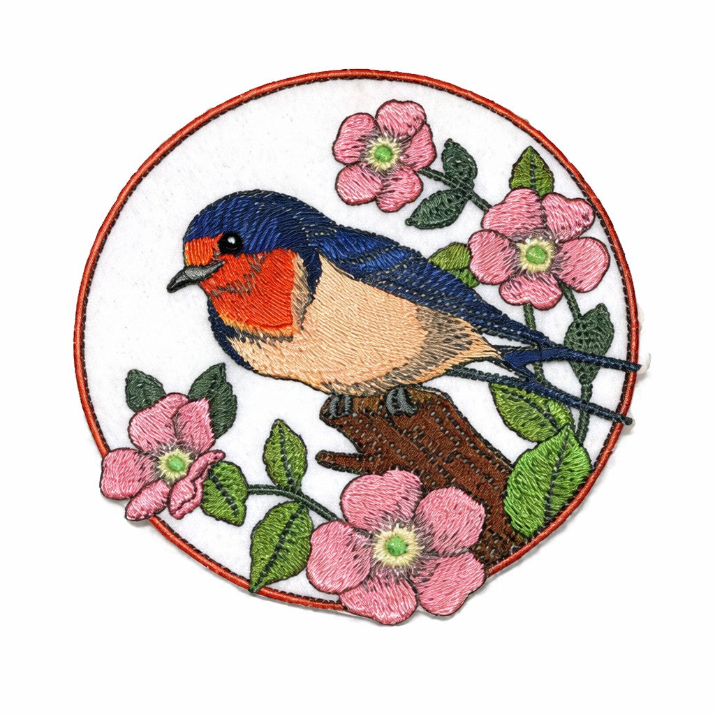 Embroidered patch of a bird and flowers on a white background